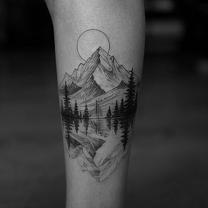 Black and grey mountain and forest calf tattoo